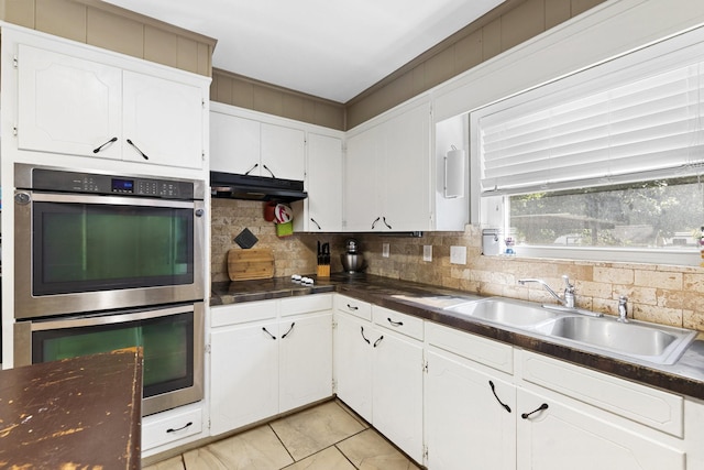 609 S Elm St, Weatherford, TX 76086 - kitchen featuring a sink, dark countertops, white cabinetry, decorative backsplash, and double oven