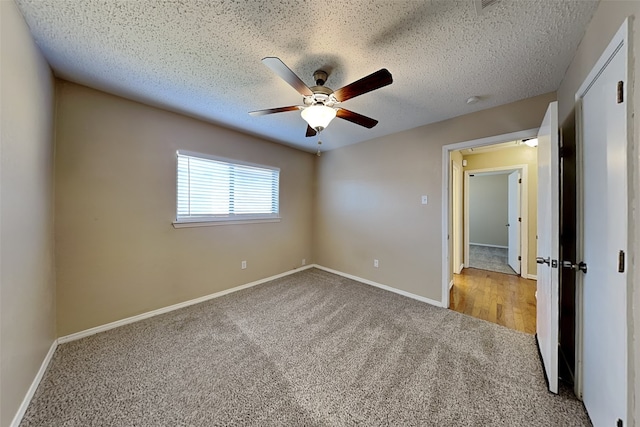 unfurnished bedroom with ceiling fan, light colored carpet, and a textured ceiling