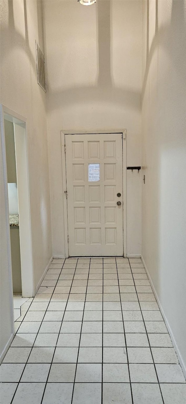 tiled foyer with a towering ceiling