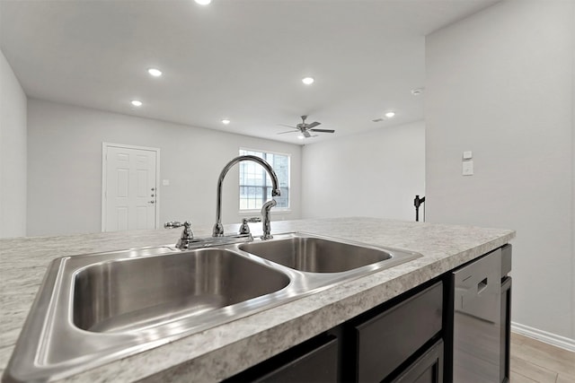 kitchen with dishwashing machine, sink, ceiling fan, and light wood-type flooring