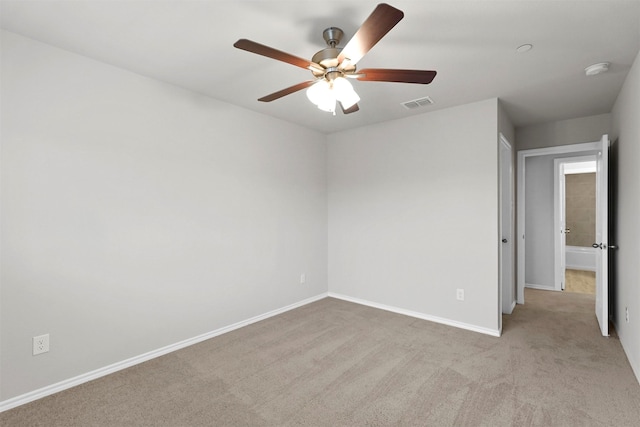 spare room with ceiling fan and light colored carpet