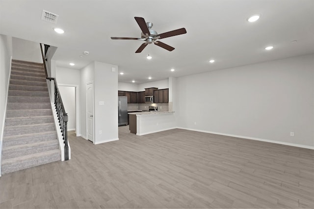 unfurnished living room featuring ceiling fan and light hardwood / wood-style flooring