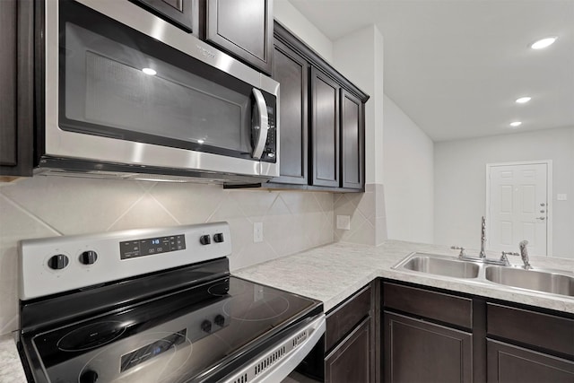 kitchen featuring dark brown cabinetry, appliances with stainless steel finishes, sink, and backsplash