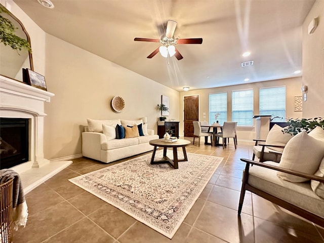 living room with ceiling fan and dark tile patterned floors