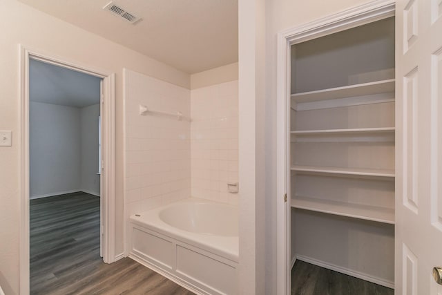 bathroom with wood-type flooring and tiled shower / bath