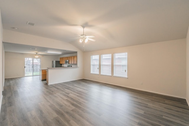 unfurnished living room featuring dark hardwood / wood-style flooring, vaulted ceiling, and ceiling fan