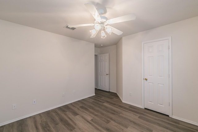 spare room featuring dark wood-type flooring and ceiling fan