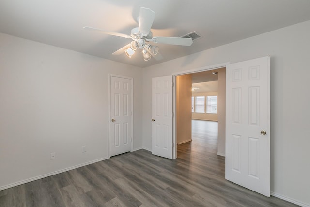 unfurnished bedroom with dark hardwood / wood-style flooring and ceiling fan