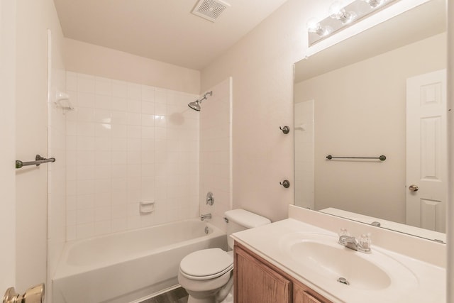 full bathroom featuring vanity, tiled shower / bath, and toilet