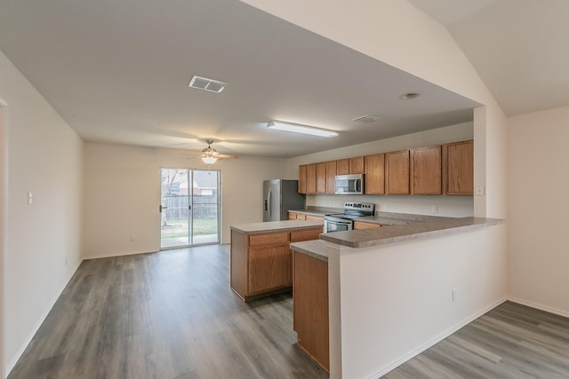 kitchen featuring stainless steel appliances, ceiling fan, light hardwood / wood-style floors, and kitchen peninsula