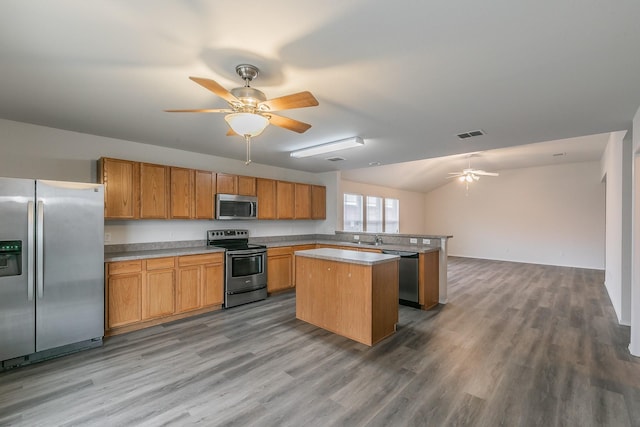 kitchen with ceiling fan, stainless steel appliances, hardwood / wood-style floors, and a kitchen island