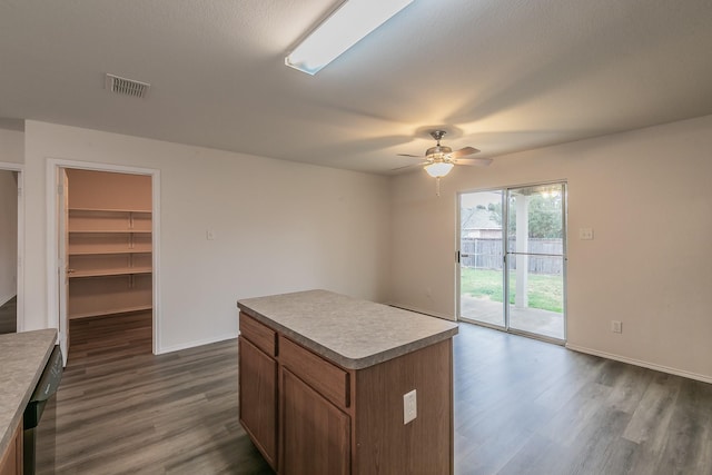 kitchen with ceiling fan, dark wood-type flooring, a center island, and dishwasher