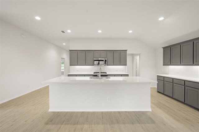 400 Basalt Dr, Azle, TX 76020 - kitchen featuring stainless steel microwave, a kitchen island with sink, backsplash, light countertops, and recessed lighting