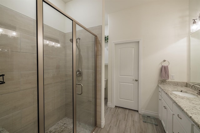 bathroom featuring hardwood / wood-style flooring, vanity, and a shower with shower door
