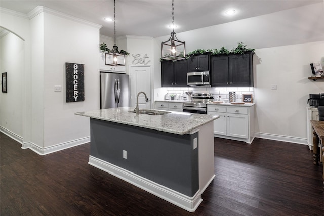 kitchen featuring sink, a kitchen island with sink, stainless steel appliances, light stone counters, and decorative light fixtures
