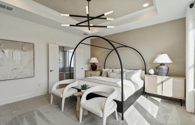 bedroom featuring light carpet and a tray ceiling