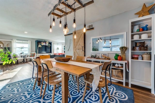 dining room with hardwood / wood-style flooring and a barn door