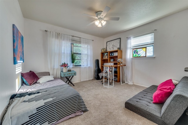 bedroom with light carpet, multiple windows, and ceiling fan