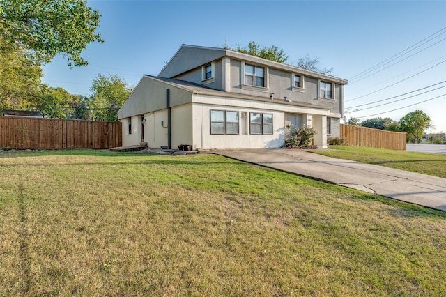 view of front of house with fence, a front lawn, and stucco siding