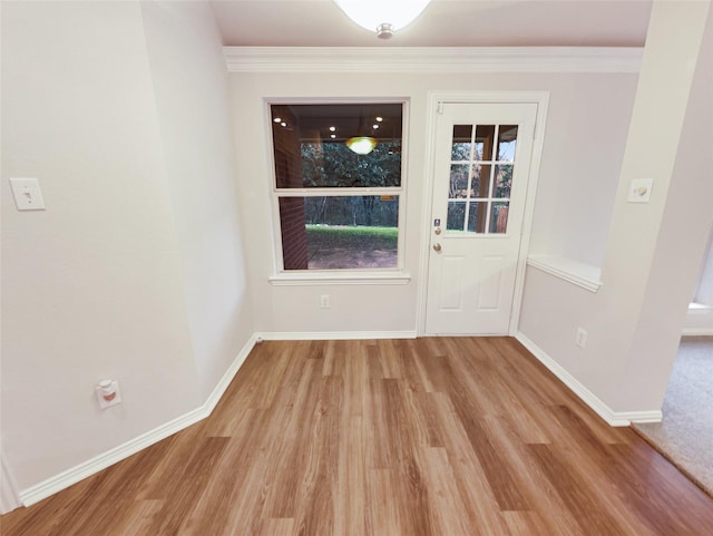 doorway to outside with ornamental molding and light hardwood / wood-style flooring