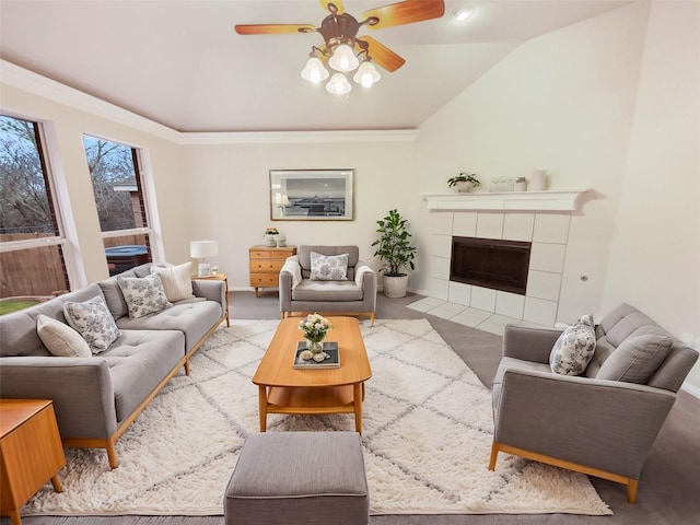 carpeted living room featuring ceiling fan, lofted ceiling, and a tiled fireplace