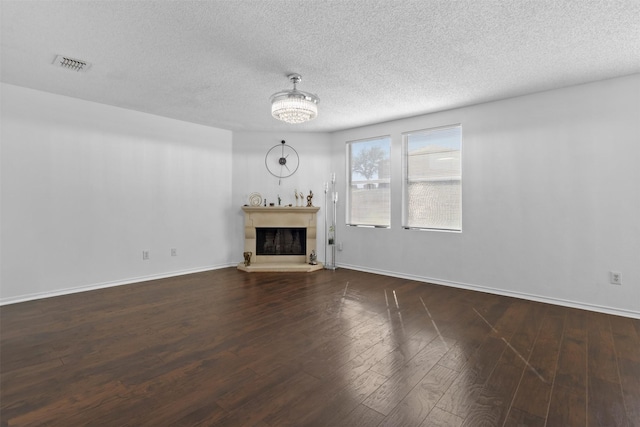 unfurnished living room with dark wood-type flooring and a textured ceiling