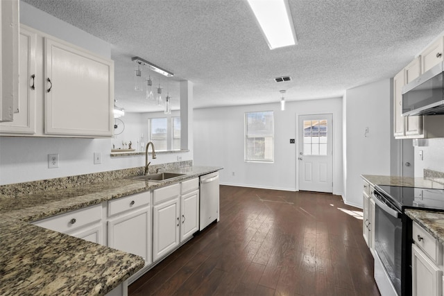 kitchen with dark wood-type flooring, sink, stone counters, stainless steel appliances, and white cabinets