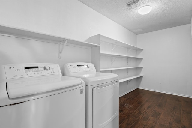 laundry room featuring dark hardwood / wood-style flooring, washer and clothes dryer, and a textured ceiling