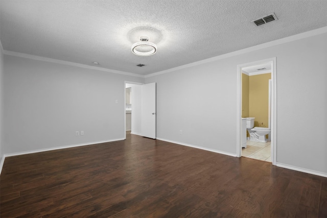 unfurnished bedroom featuring ornamental molding, dark wood-type flooring, a textured ceiling, and ensuite bath