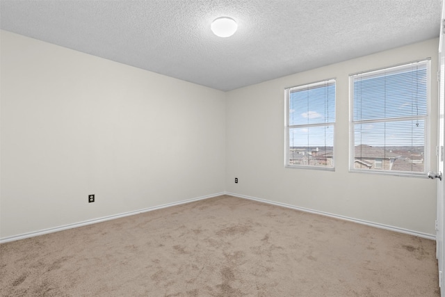 carpeted empty room with a textured ceiling