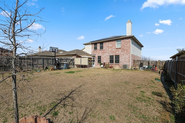 rear view of property featuring a yard and cooling unit