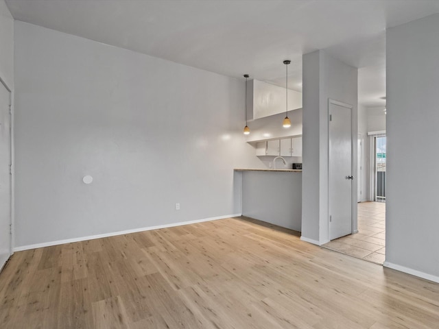 unfurnished living room featuring high vaulted ceiling and light hardwood / wood-style flooring