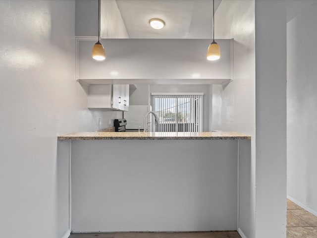 kitchen featuring pendant lighting, white cabinetry, and stainless steel electric range