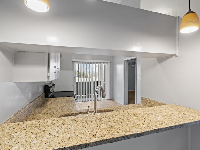 kitchen with sink, pendant lighting, kitchen peninsula, electric stove, and white cabinets