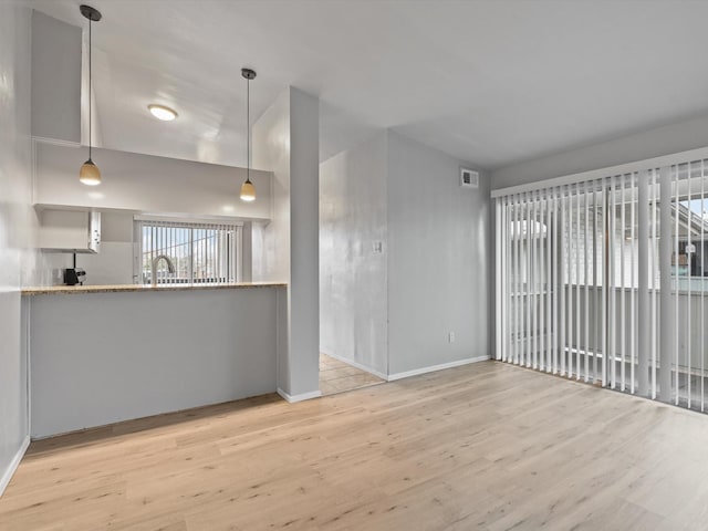 unfurnished living room featuring sink and light hardwood / wood-style flooring