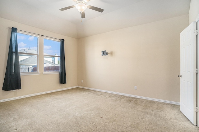 carpeted spare room featuring vaulted ceiling and ceiling fan