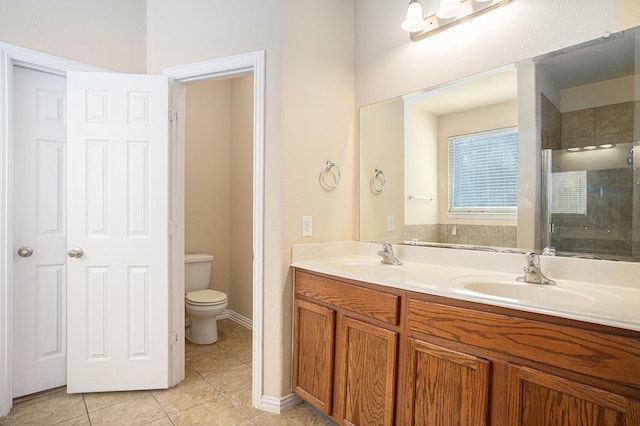 bathroom featuring vanity, a shower with door, tile patterned floors, and toilet