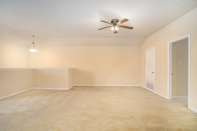 spare room with vaulted ceiling, light carpet, and ceiling fan