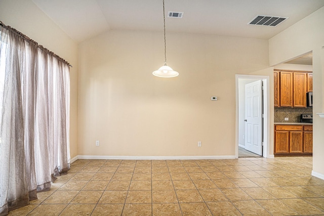 unfurnished dining area featuring vaulted ceiling and light tile patterned flooring