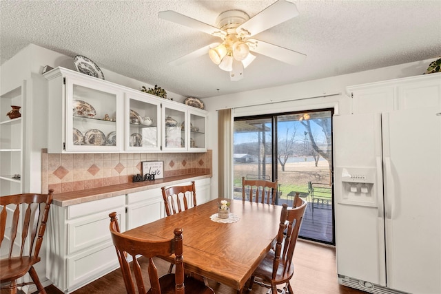 dining space featuring ceiling fan, a textured ceiling, and light hardwood / wood-style flooring