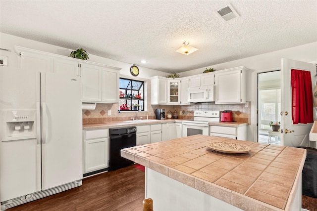 kitchen with dark hardwood / wood-style floors, white cabinetry, sink, and white appliances