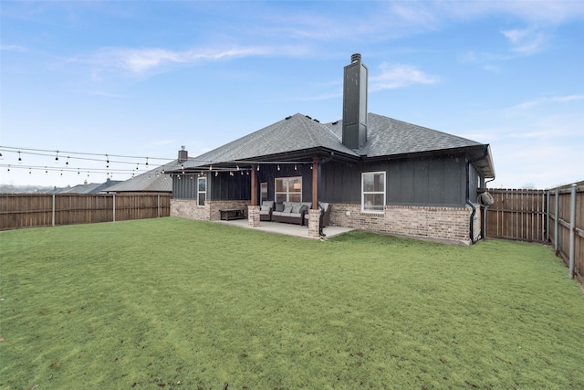 rear view of property with a lawn and a patio