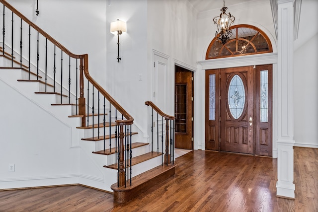 foyer featuring a high ceiling, wood-type flooring, and a notable chandelier