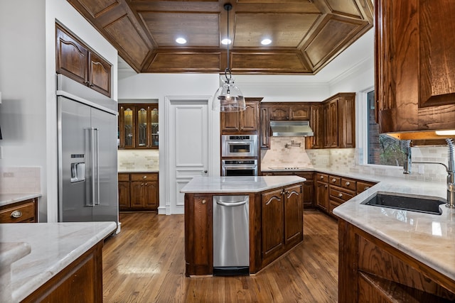 kitchen featuring sink, crown molding, stainless steel appliances, a center island, and light stone countertops