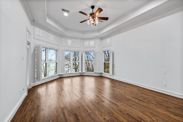 spare room with a raised ceiling, crown molding, hardwood / wood-style floors, and ceiling fan