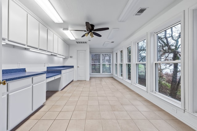 kitchen with white cabinetry, light tile patterned floors, and ceiling fan