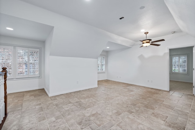 additional living space featuring vaulted ceiling, plenty of natural light, and ceiling fan