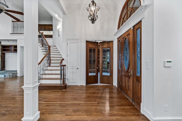 foyer entrance featuring dark hardwood / wood-style flooring, a notable chandelier, and ornamental molding