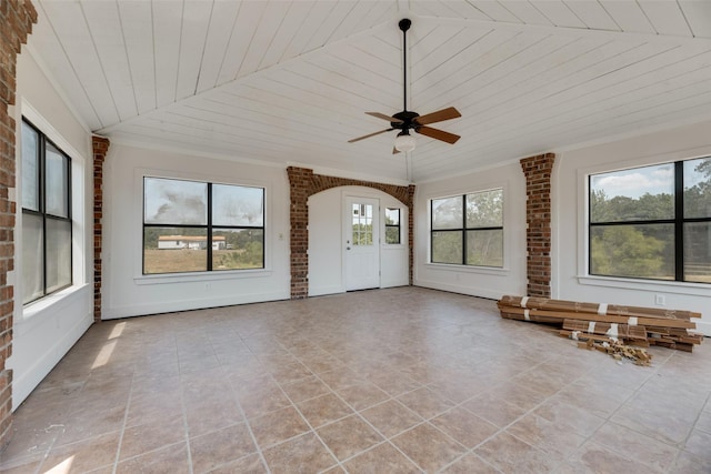 unfurnished living room featuring brick wall, wooden ceiling, and ceiling fan