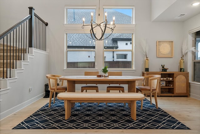 dining area featuring visible vents, baseboards, stairs, an inviting chandelier, and light wood-style floors